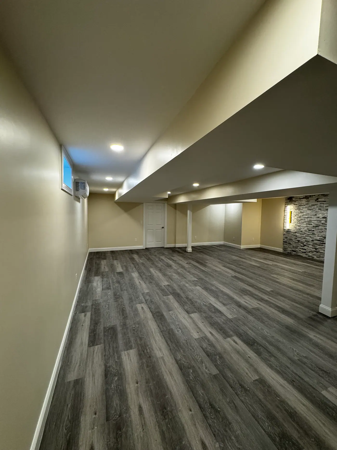 Lower Level Living Room — Vinyl plank flooring and stone accent
