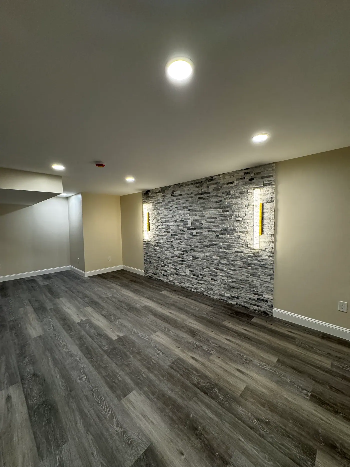 Basement Feature Wall — Full-height stacked stone with recessed lighting