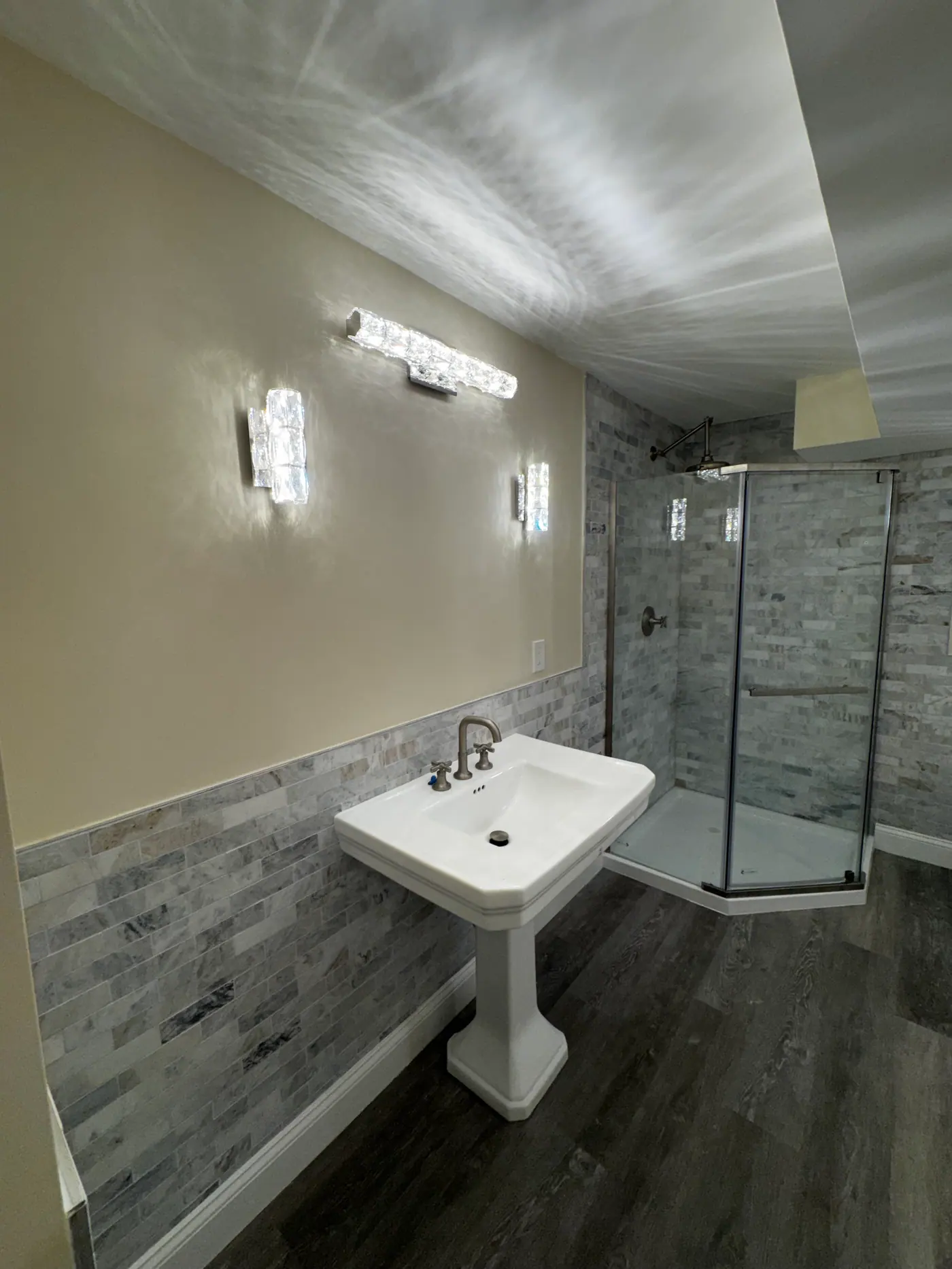 Lower Level Bathroom — Pedestal sink and marble tile surround