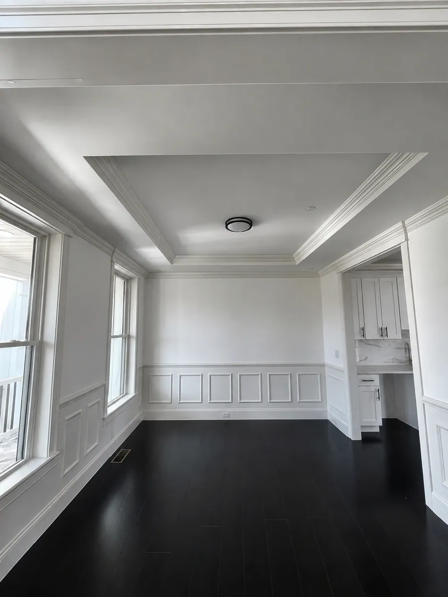 Dining room with tray ceiling, panelled wainscoting and dark hardwood floors