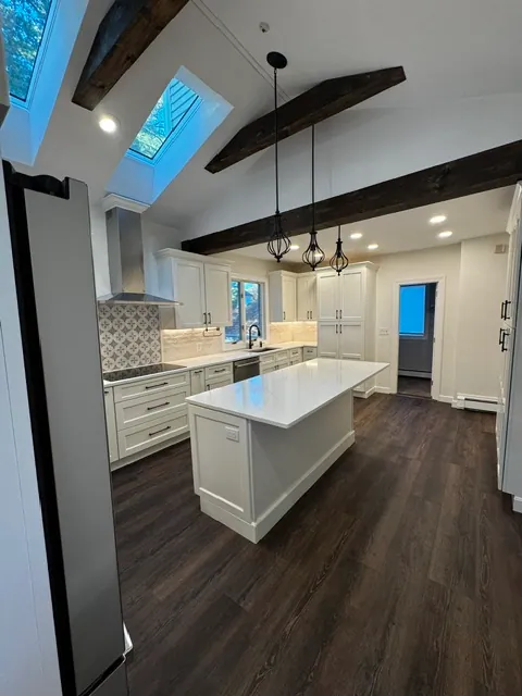 Remodeled kitchen with exposed beams and quartz island